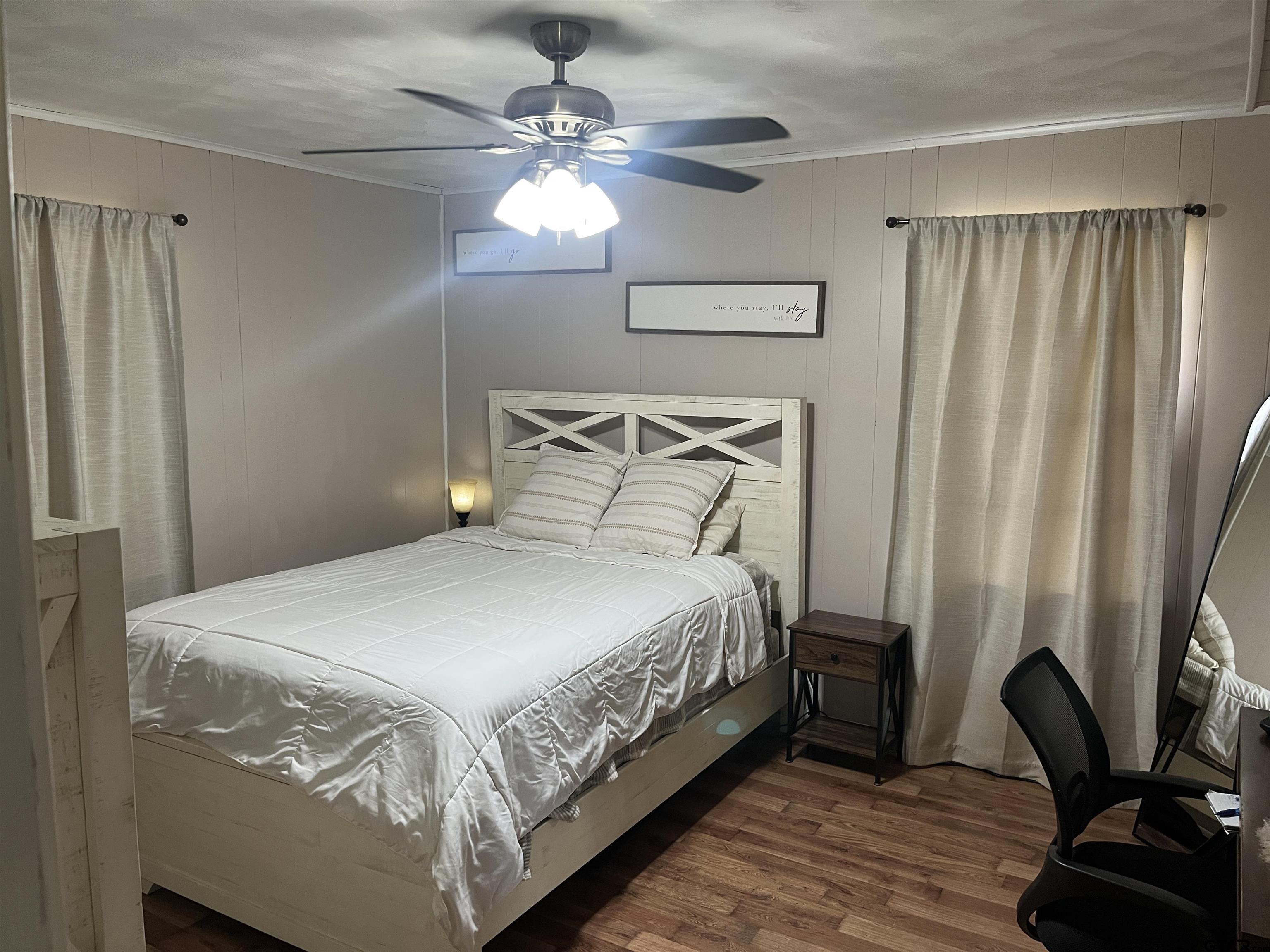 407 Fulton Street Pittsburg, TX 75686 - Photo 12 of 30 a bedroom with a bed and a chandelier