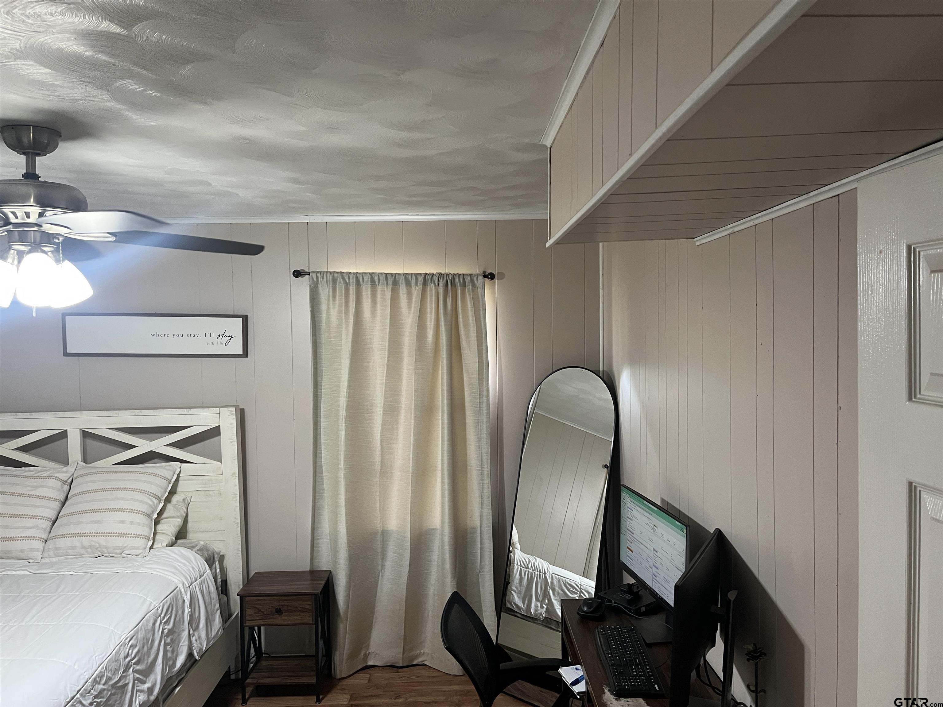 407 Fulton Street Pittsburg, TX 75686 - Photo 13 of 30 a bedroom with a bed and a mirror