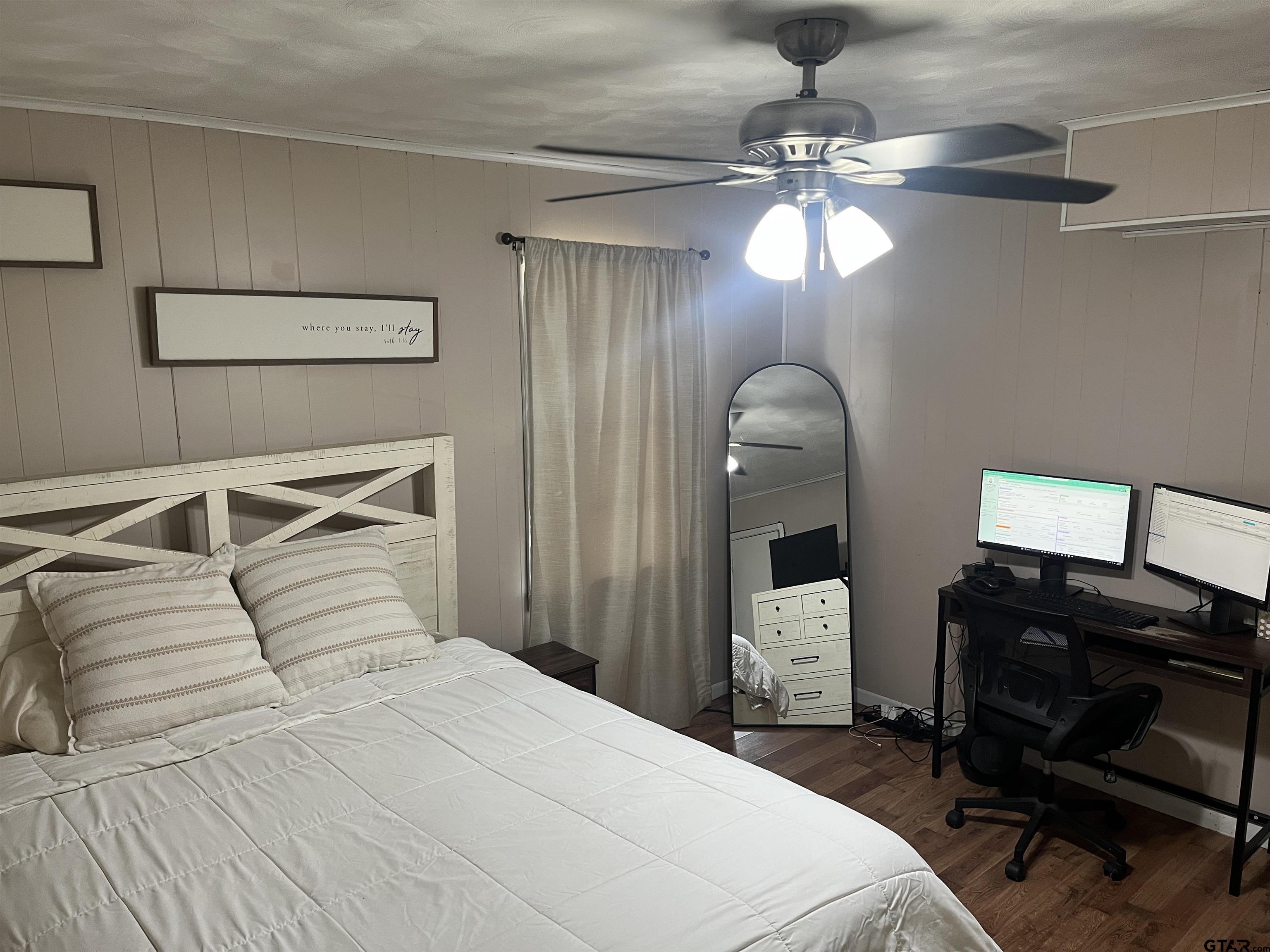 407 Fulton Street Pittsburg, TX 75686 - Photo 15 of 30 a bedroom with a bed and a chandelier