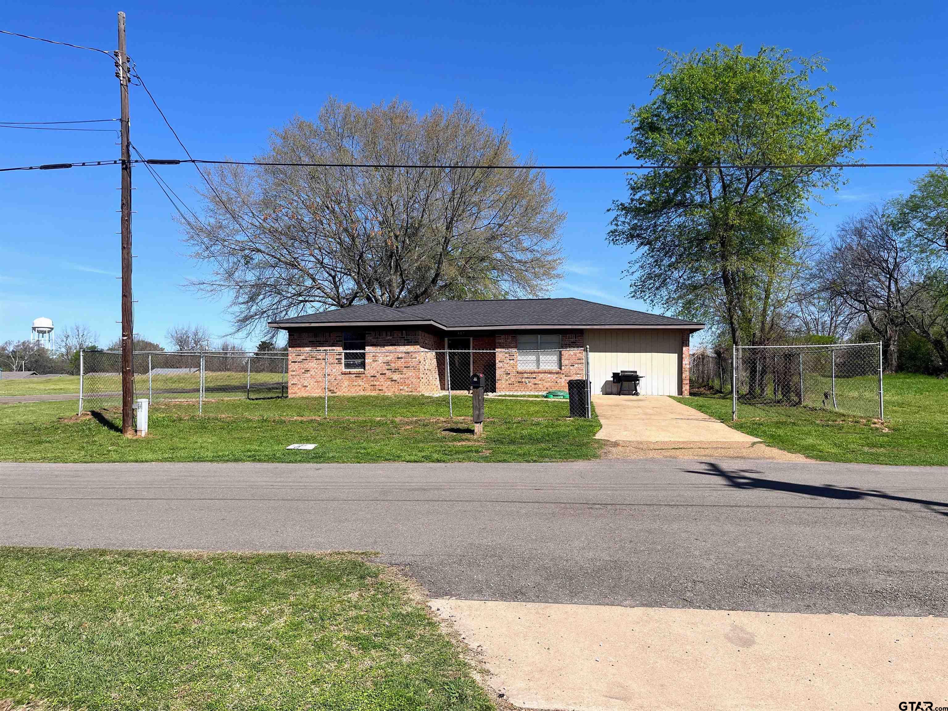 407 Fulton Street Pittsburg, TX 75686 - Photo 30 of 30 a front view of a house with a yard and garage
