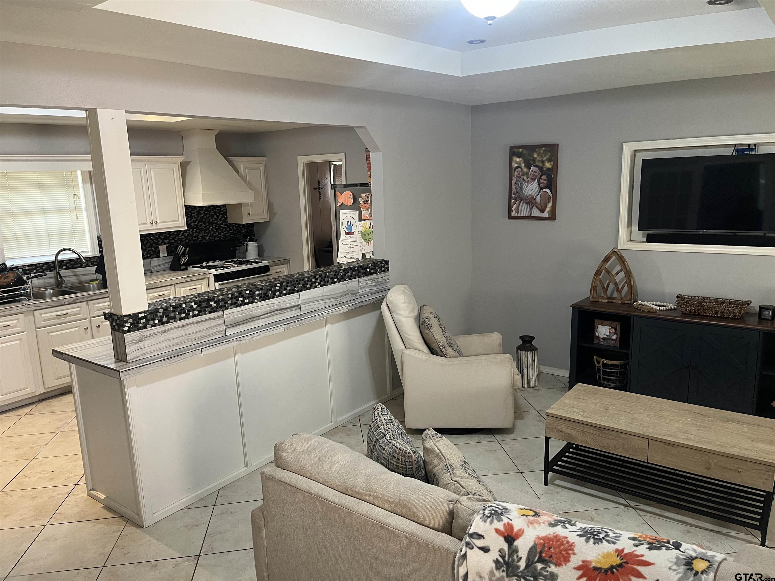 407 Fulton Street Pittsburg, TX 75686 - Photo 5 of 30 a living room with furniture and a flat screen tv