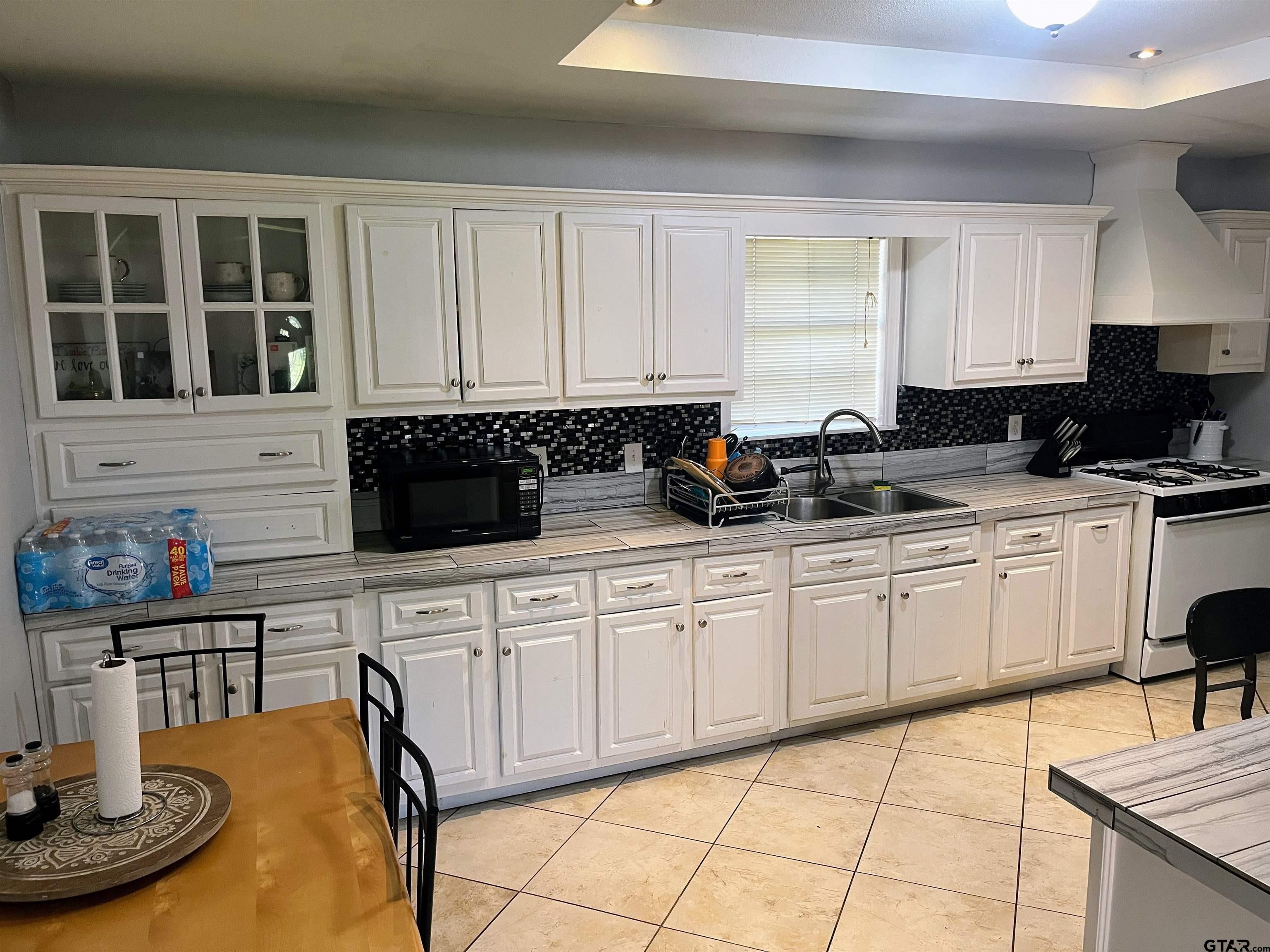 407 Fulton Street Pittsburg, TX 75686 - Photo 7 of 30 a kitchen with stainless steel appliances granite countertop a sink and cabinets
