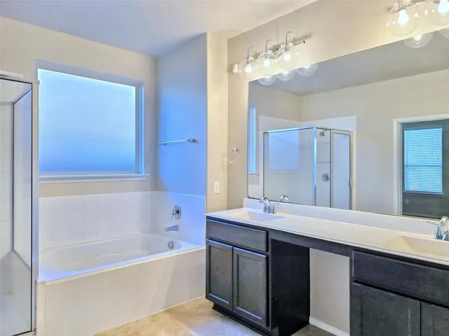 a bathroom with a tub a sink and mirror