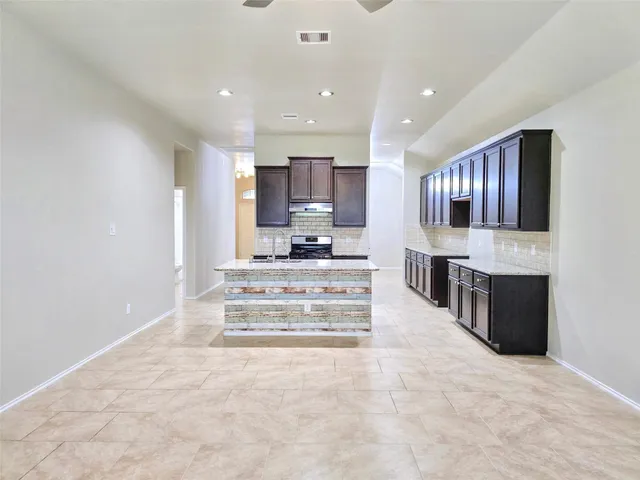 a view of kitchen with kitchen island microwave and cabinets