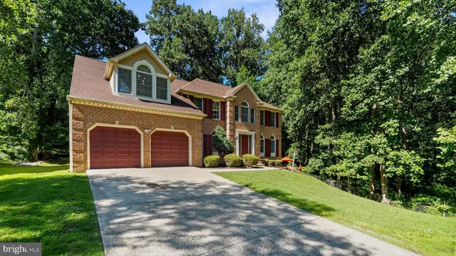 a front view of a house with a garden and trees