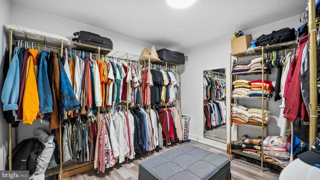 a view of walk in closet with clothes and shoes