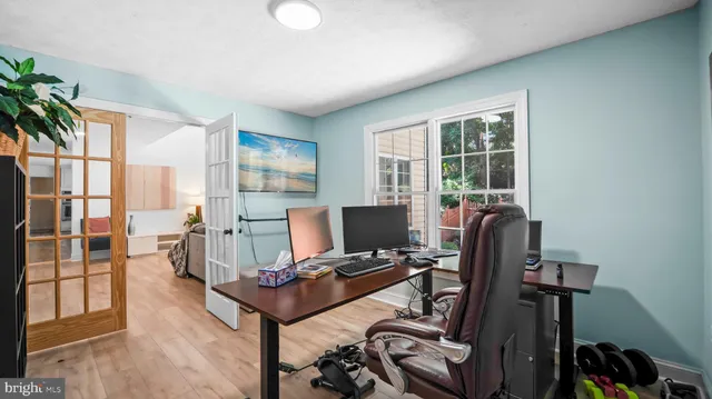 a view of a workspace with furniture and a window