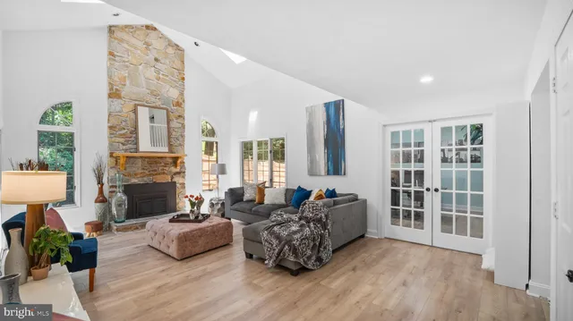 a living room with furniture large window and wooden floor