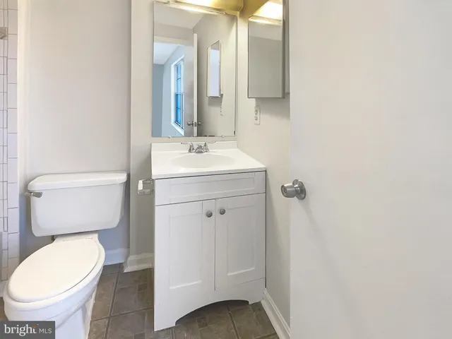 a bathroom with a toilet sink and mirror