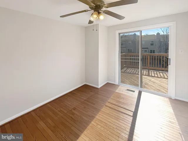 a view of a room with wooden floor and fan