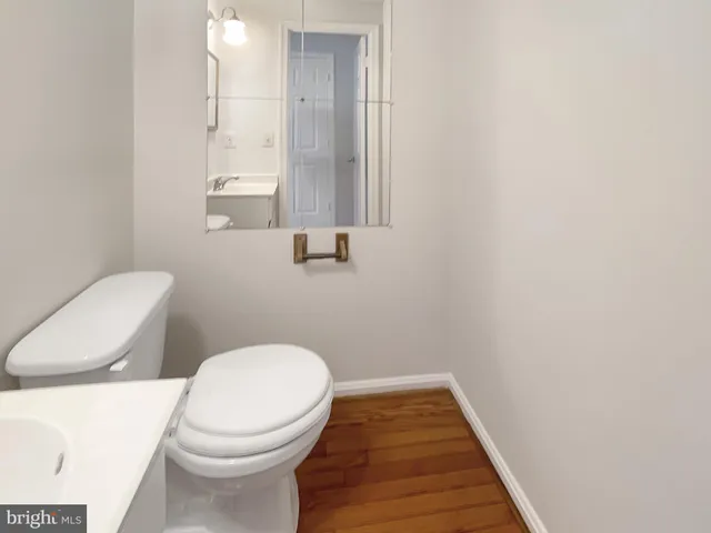 a white toilet sitting next to a wooden cabinet