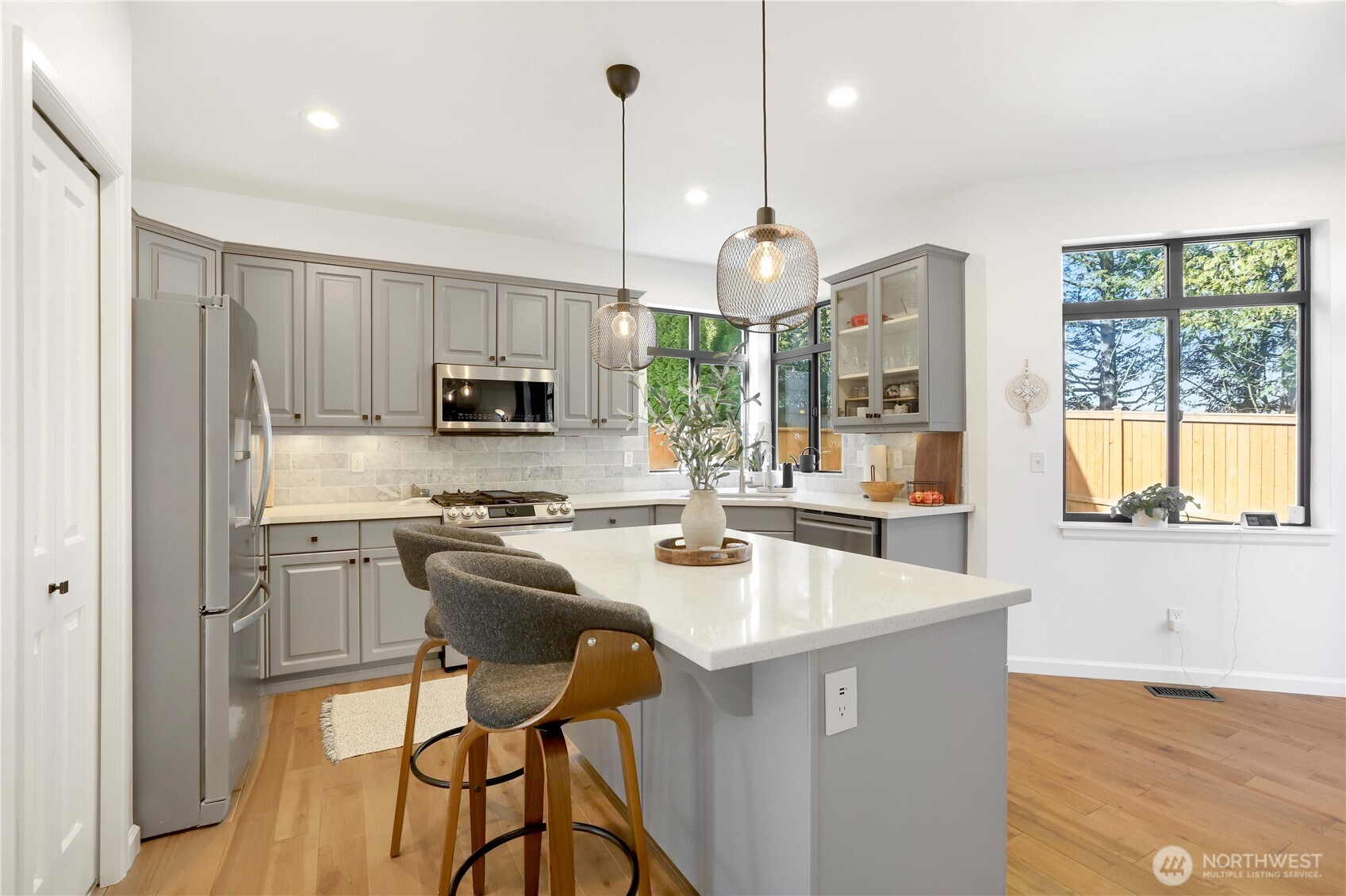 7531 148th Place Southeast Snohomish, WA 98296 - Photo 12 of 29 a kitchen with stainless steel appliances granite countertop a stove a sink a microwave a refrigerator a stove and white cabinets with wooden floor