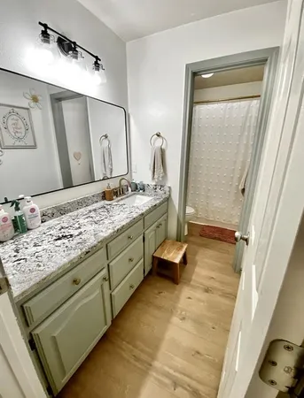 a bathroom with a granite countertop sink and a mirror