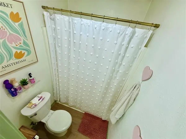 a bathroom with a sink toilet and shower curtain