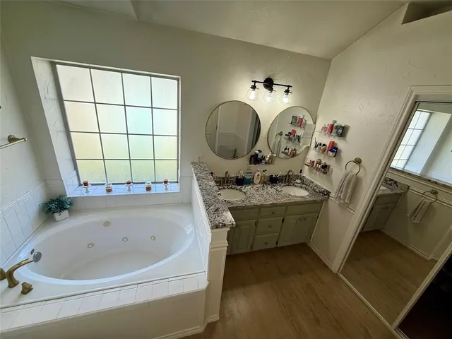 a bathroom with a tub sink and mirror