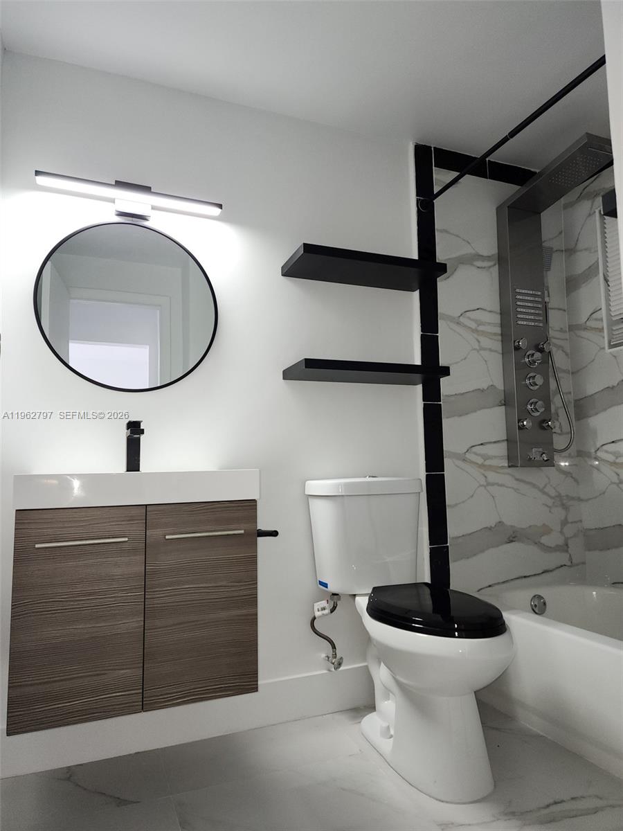 2101 Normandy Drive, Unit 204 Miami Beach, FL 33141 - Photo 43 of 43 a bathroom with a toilet sink and mirror