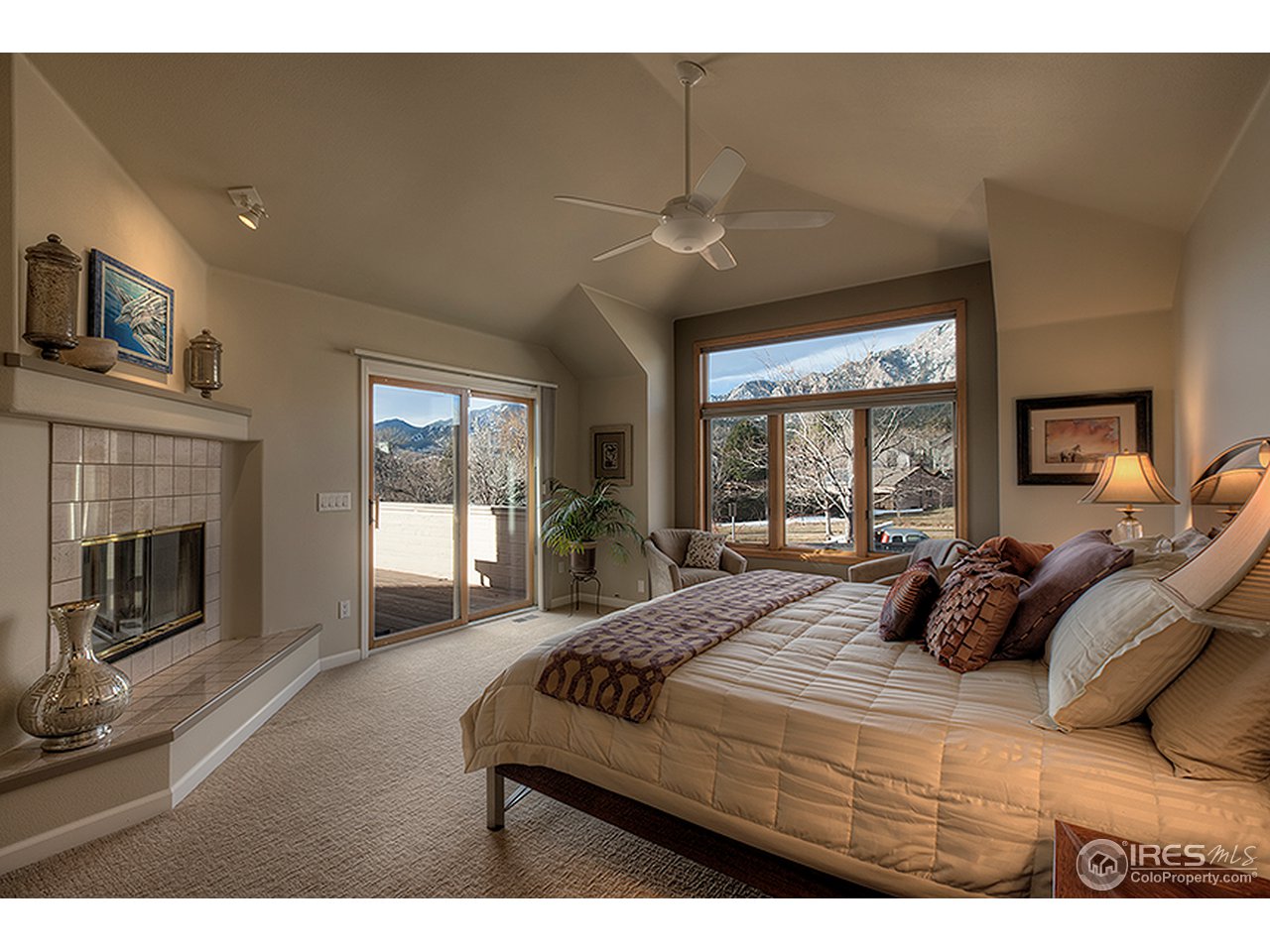 3180 Redstone Road Boulder, CO 80305 - Photo 7 of 24 a bedroom with a bed a fireplace and large windows