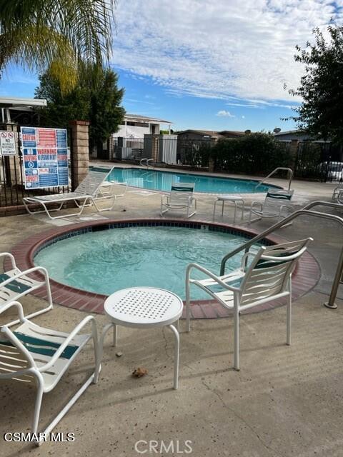 24303 Woolsey Canyon Road, Unit 26 Canoga Park, CA 91304 - Photo 24 of 28 a swimming pool with outdoor seating and a garden