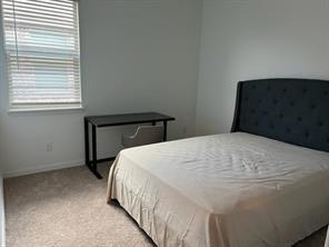 719 Biscay Way Princeton, TX 75407 - Photo 11 of 24 a bed sitting in a bedroom next to a window