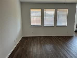 719 Biscay Way Princeton, TX 75407 - Photo 3 of 24 an empty room with wooden floor and windows