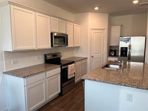 719 Biscay Way Princeton, TX 75407 - Photo 5 of 24 a kitchen with granite countertop a sink a counter top space stainless steel appliances and cabinets