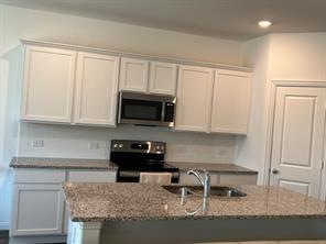 719 Biscay Way Princeton, TX 75407 - Photo 6 of 24 a kitchen with stainless steel appliances granite countertop a stove a sink and a white cabinets