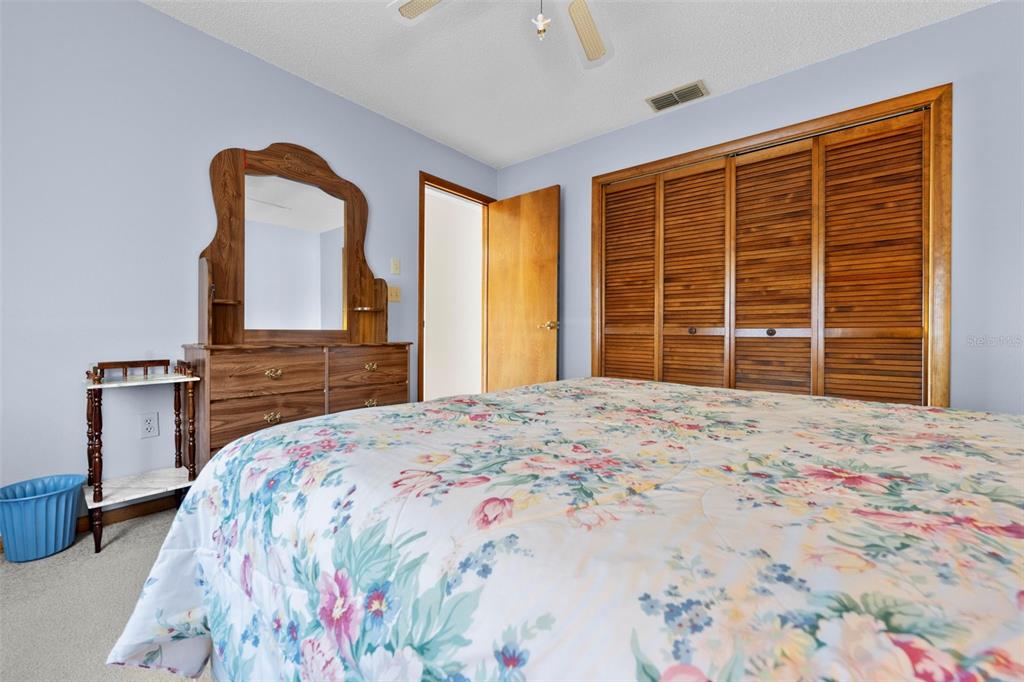 1446 Cornell Avenue Spring Hill, FL 34609 - Photo 26 of 39 a bedroom with a bed and a dresser with mirror