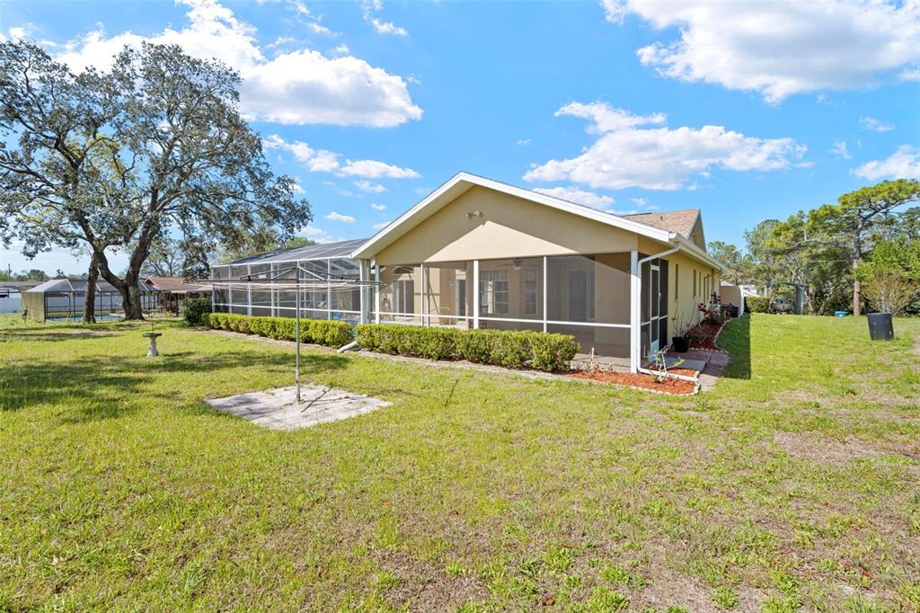 1446 Cornell Avenue Spring Hill, FL 34609 - Photo 35 of 39 a view of a house with a big yard and large trees