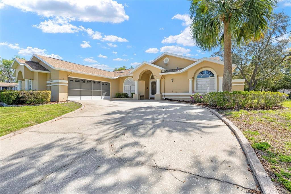 1446 Cornell Avenue Spring Hill, FL 34609 - Photo 37 of 39 a front view of a house with a yard and garage
