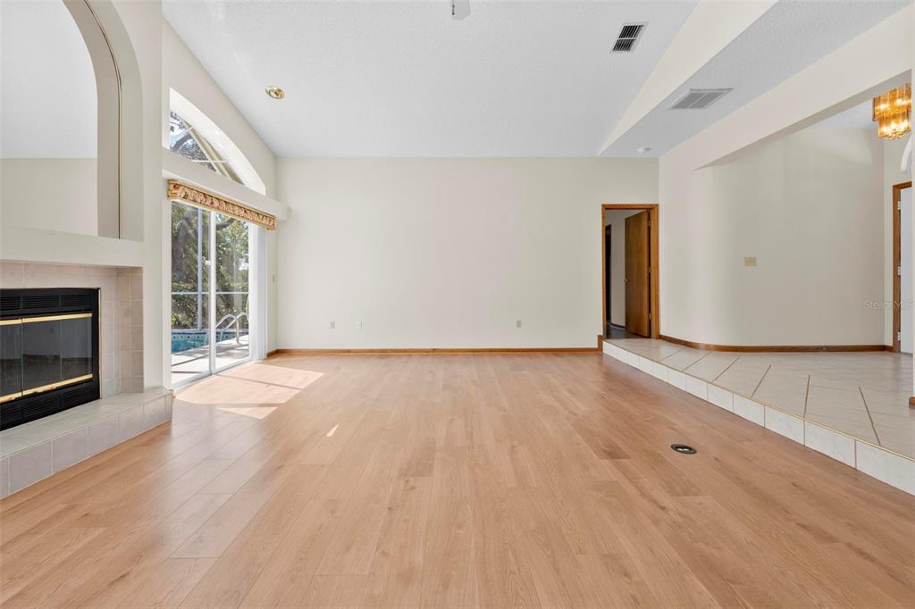 1446 Cornell Avenue Spring Hill, FL 34609 - Photo 9 of 39 a view of an empty room with wooden floor fireplace and a window