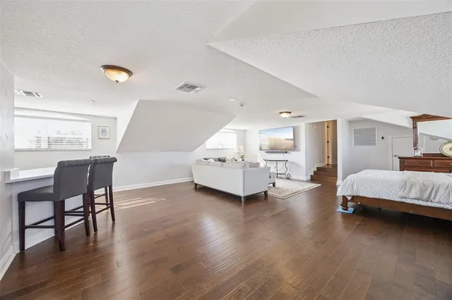 a bedroom with a bed lamps and wooden floor