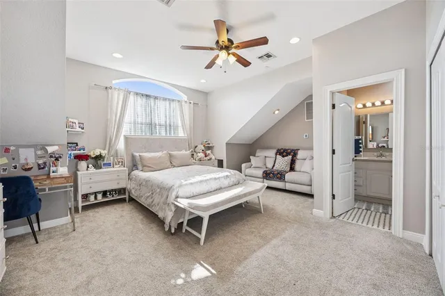 a bedroom with a bed a chandelier and a window