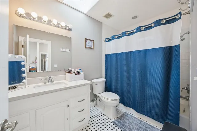 a spacious bathroom with a bathtub double sink and mirror
