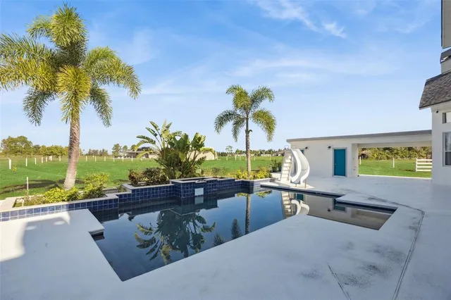 an aerial view of a house with a garden and lake view