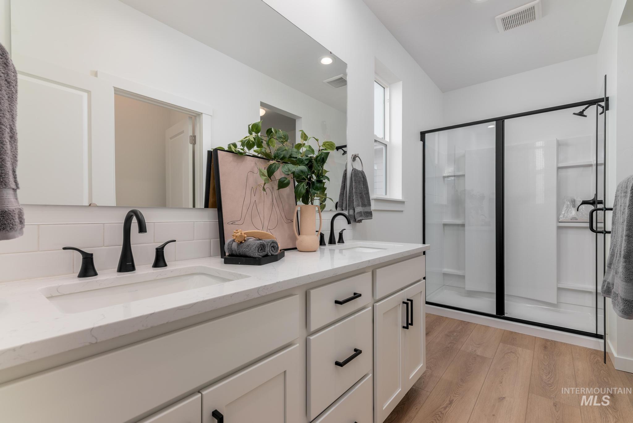 14726 Wing Spread Drive Caldwell, ID 83607 - Photo 19 of 35 Bathroom with double vanity, light wood-style floors, a stall shower, decorative backsplash, and recessed lighting