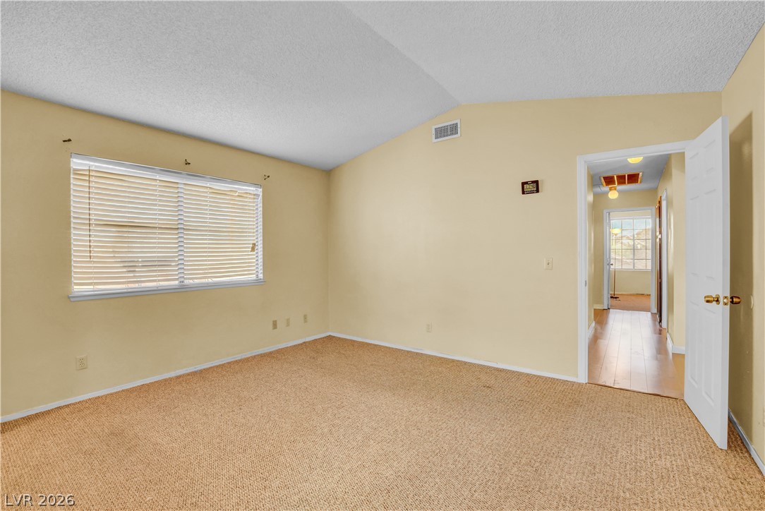 6440 Hartwood Road Las Vegas, NV 89108 - Photo 28 of 59 A quiet bedroom with vaulted ceilings and textured carpeting.