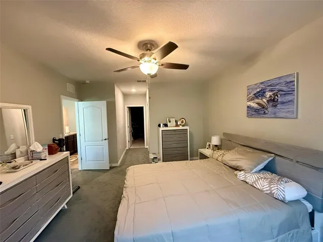 a bedroom with a large bed and a chandelier