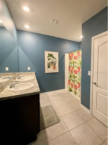 a room with kitchen island a sink a counter top space and stainless steel appliances