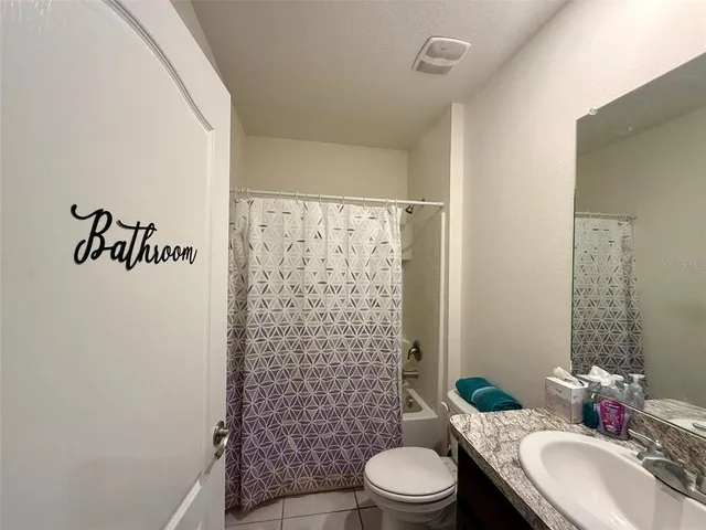 a bathroom with a sink a toilet and shower curtain