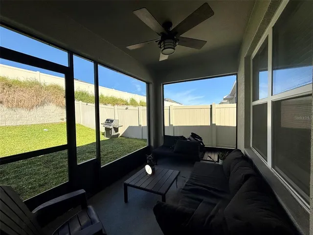 a living room with furniture and a floor to ceiling window
