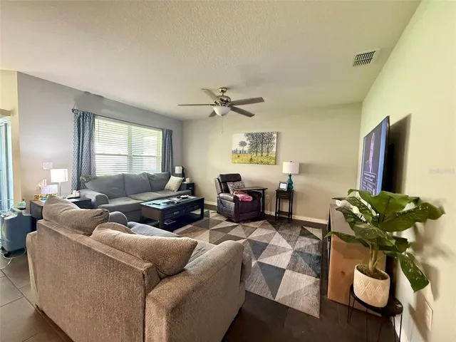 a living room with furniture flowerpot and a chandelier