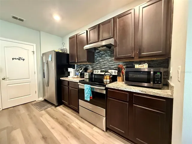 a kitchen with stainless steel appliances granite countertop a refrigerator stove and sink