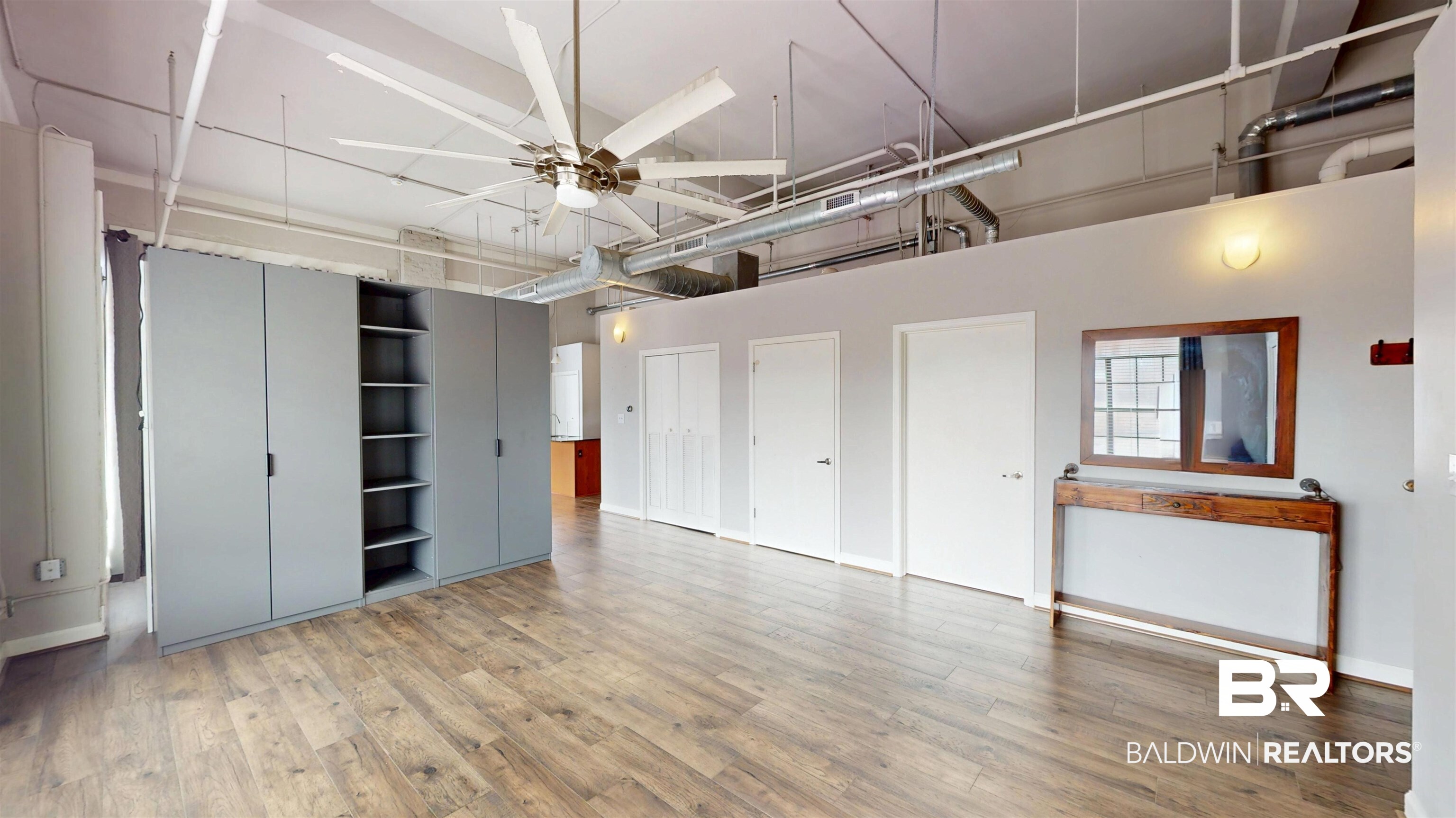 308 St Louis Street, Unit 101 Mobile, AL 36602 - Photo 19 of 30 Unfurnished bedroom with light wood finished floors, two closets, ceiling fan, and a high ceiling