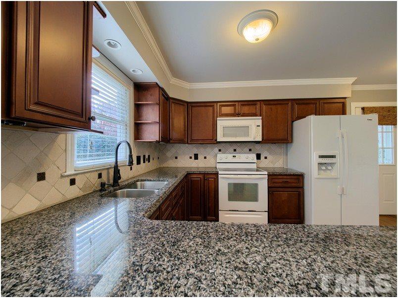2521 Village Grove Road Raleigh, NC 27613 - Photo 6 of 25 a kitchen with granite countertop a refrigerator stove and sink