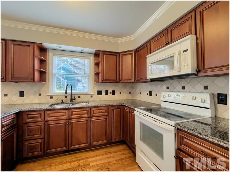2521 Village Grove Road Raleigh, NC 27613 - Photo 7 of 25 a kitchen with stainless steel appliances granite countertop a sink stove and microwave
