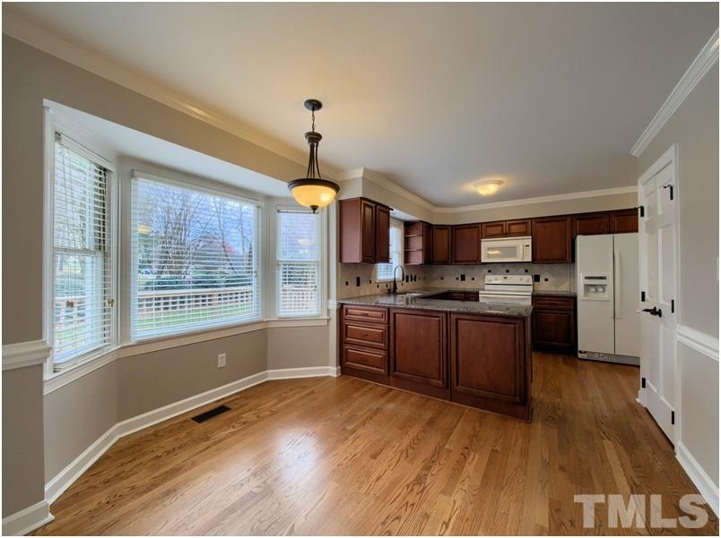 2521 Village Grove Road Raleigh, NC 27613 - Photo 10 of 25 a large kitchen with a lot of counter space and wooden floor