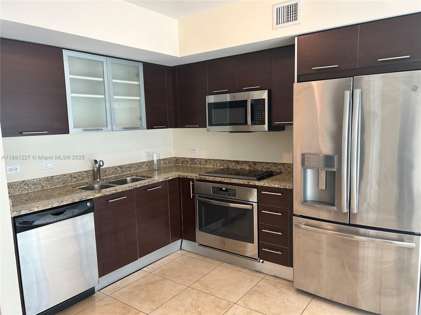 41 Southeast 5th Street, Unit 1108 Miami, FL 33131 - Photo 2 of 8 a kitchen with stainless steel appliances granite countertop a refrigerator and a stove top oven