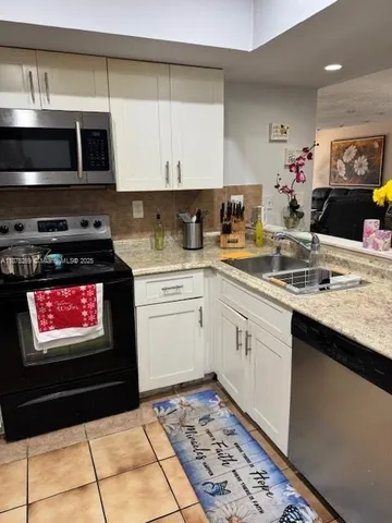a kitchen with stainless steel appliances kitchen island granite countertop a sink and cabinets