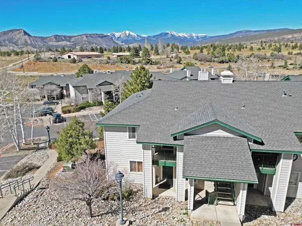 an aerial view of a house with a yard and lake view