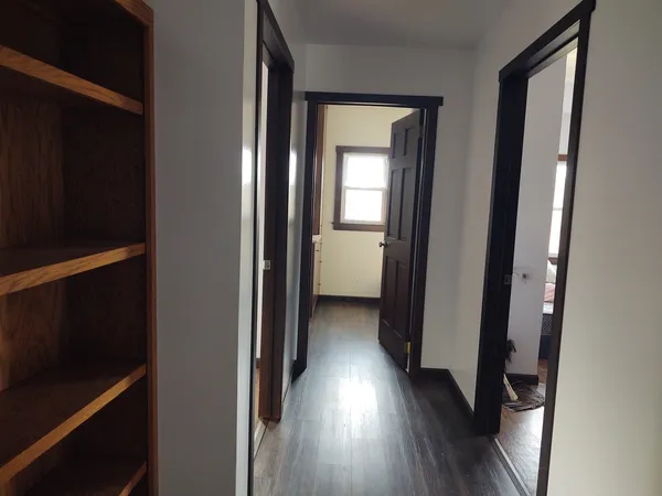 a view of a hallway with wooden floor